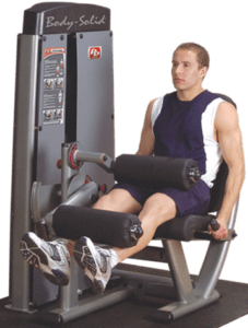 Man using leg extension exercise machine.