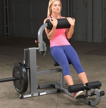 Woman exercising on a seated row machine in a gym.