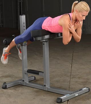 Woman exercising the lower back on a hyperextension bench.