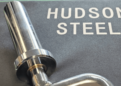 Close-up of a metallic tool on a surface with 'HUDSON STEEL' text.