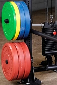 Close-up of a barbell and weight rack in a gym.