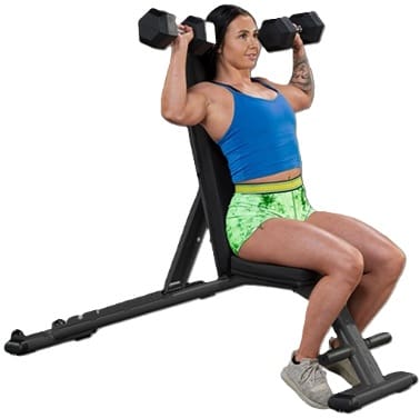 Woman lifting dumbbells while seated on a workout bench.