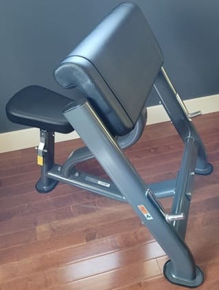 Close-up of a seated exercise machine on wooden flooring.